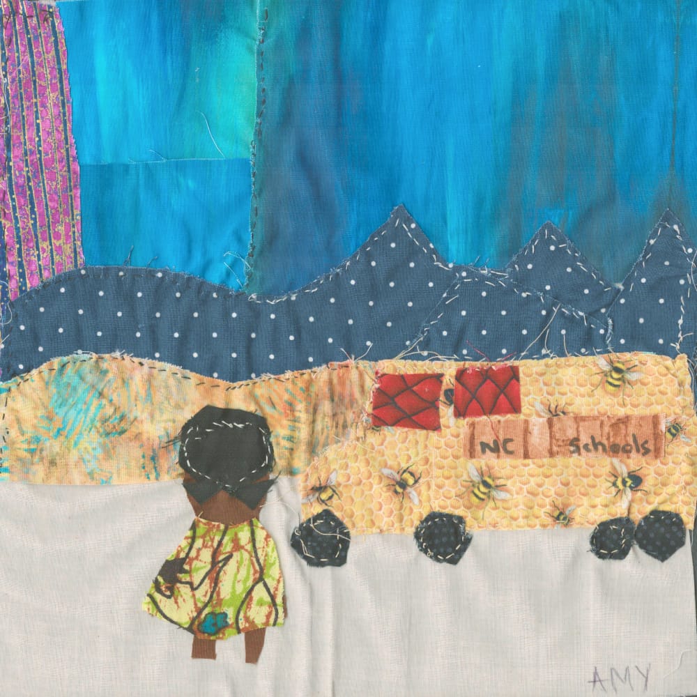 A quilt square depicting an African American girl and a school bus in front of a mountain scene