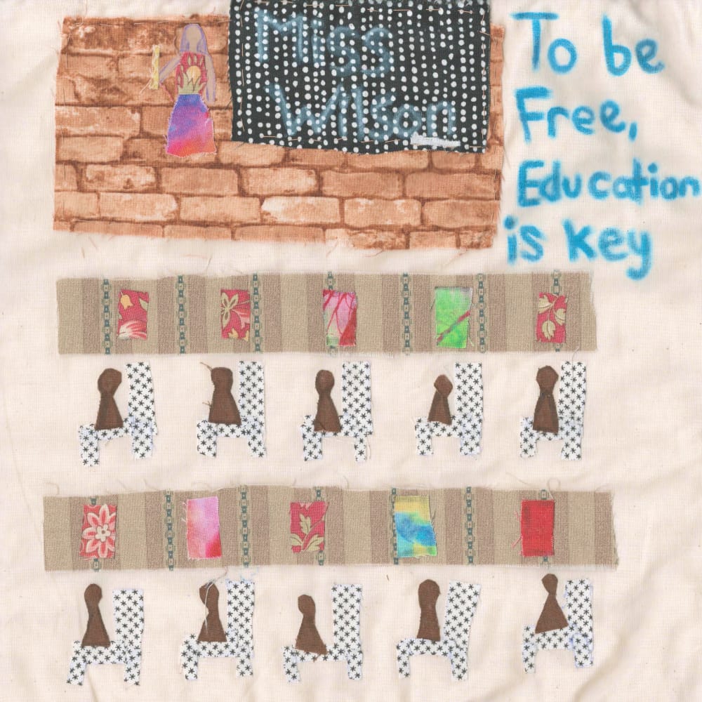 A teacher, Mrs. Wilson, stands at the front with a chalkboard. A quilt square depicting a classroom with African American children at desks. Written in the upper left is the quote "To be free, education is key"