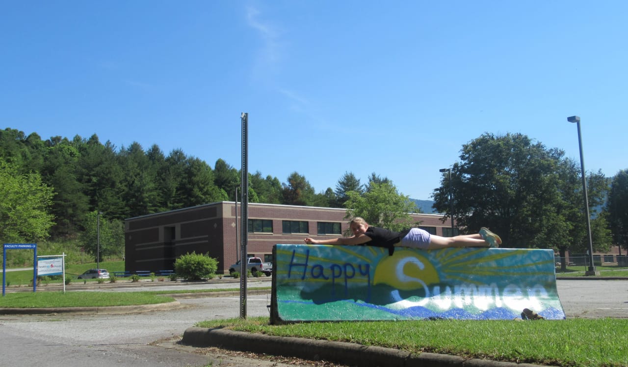 A young girl relaxing on top of a large sign
